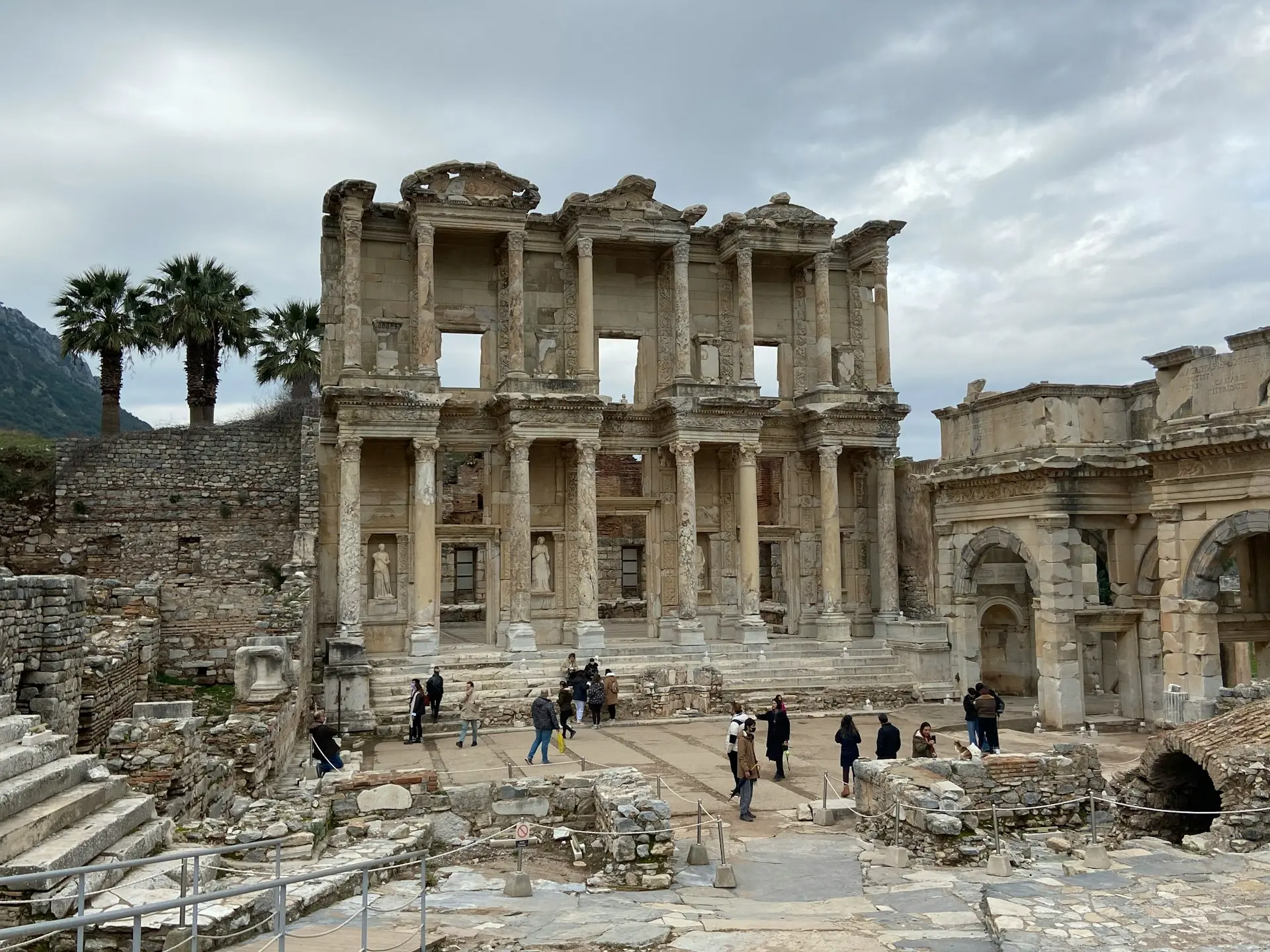 a group of people walking around a stone building