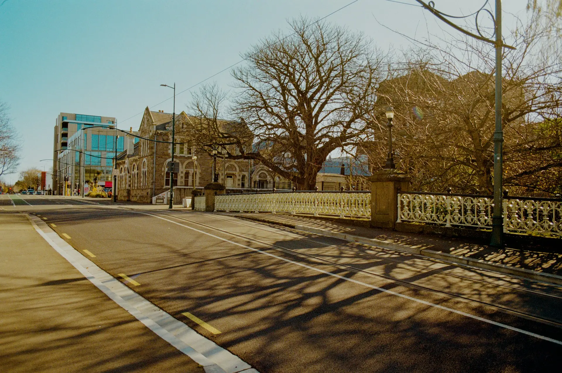a street with a fence and a building in the background