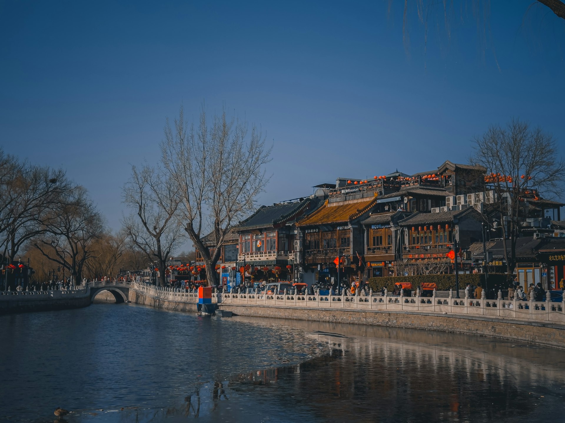 a group of people walking on a bridge over a river
