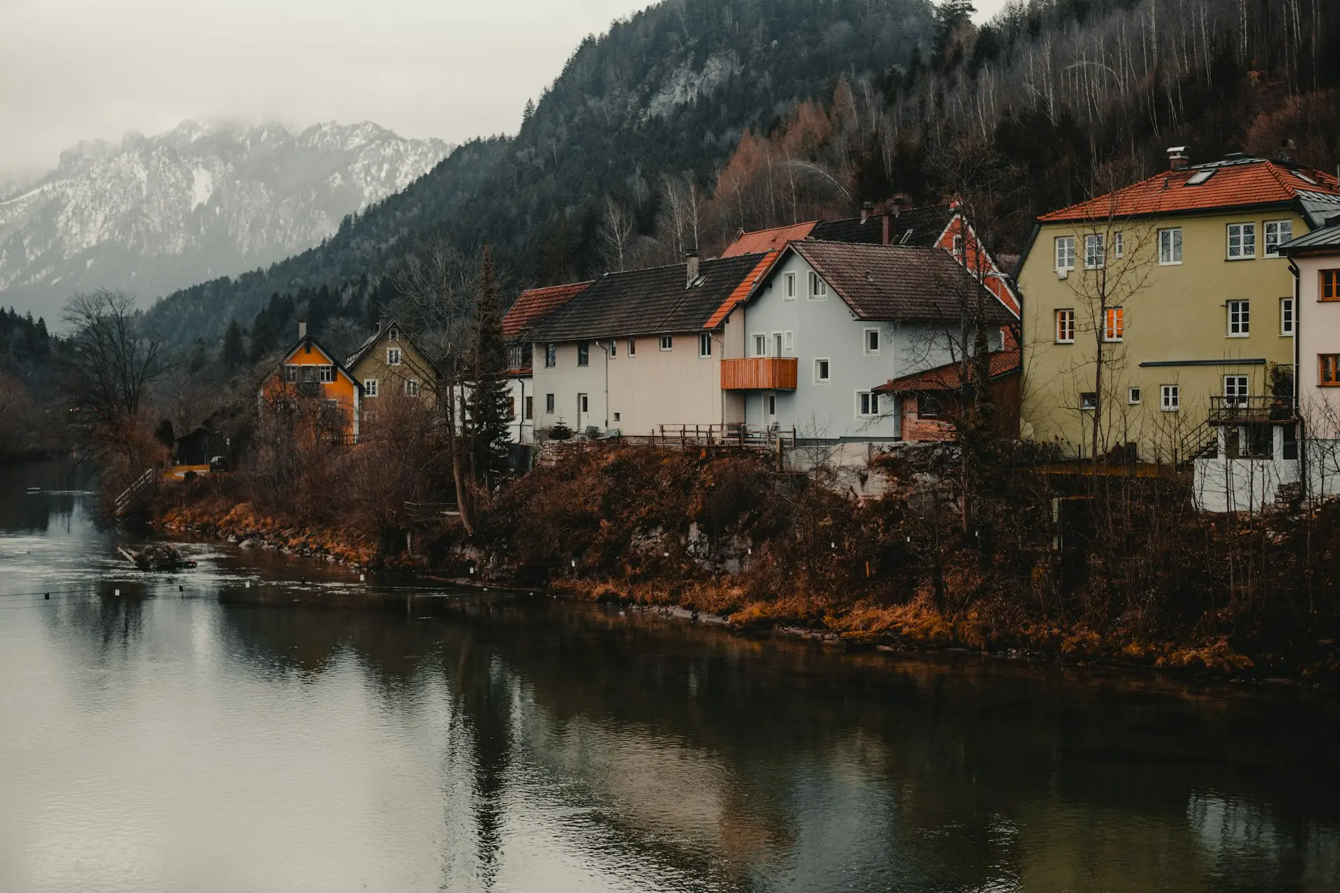 white and brown concrete house beside body of water during daytime