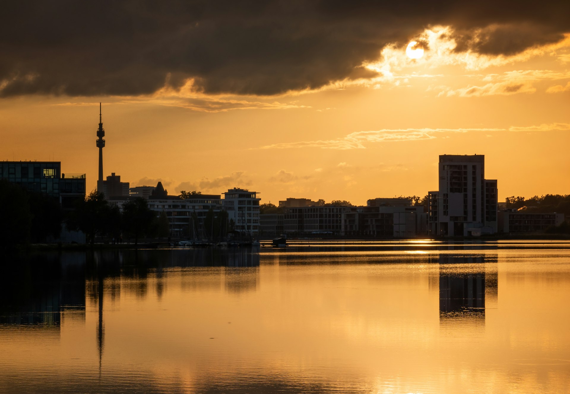 The sun is setting over a city and a body of water