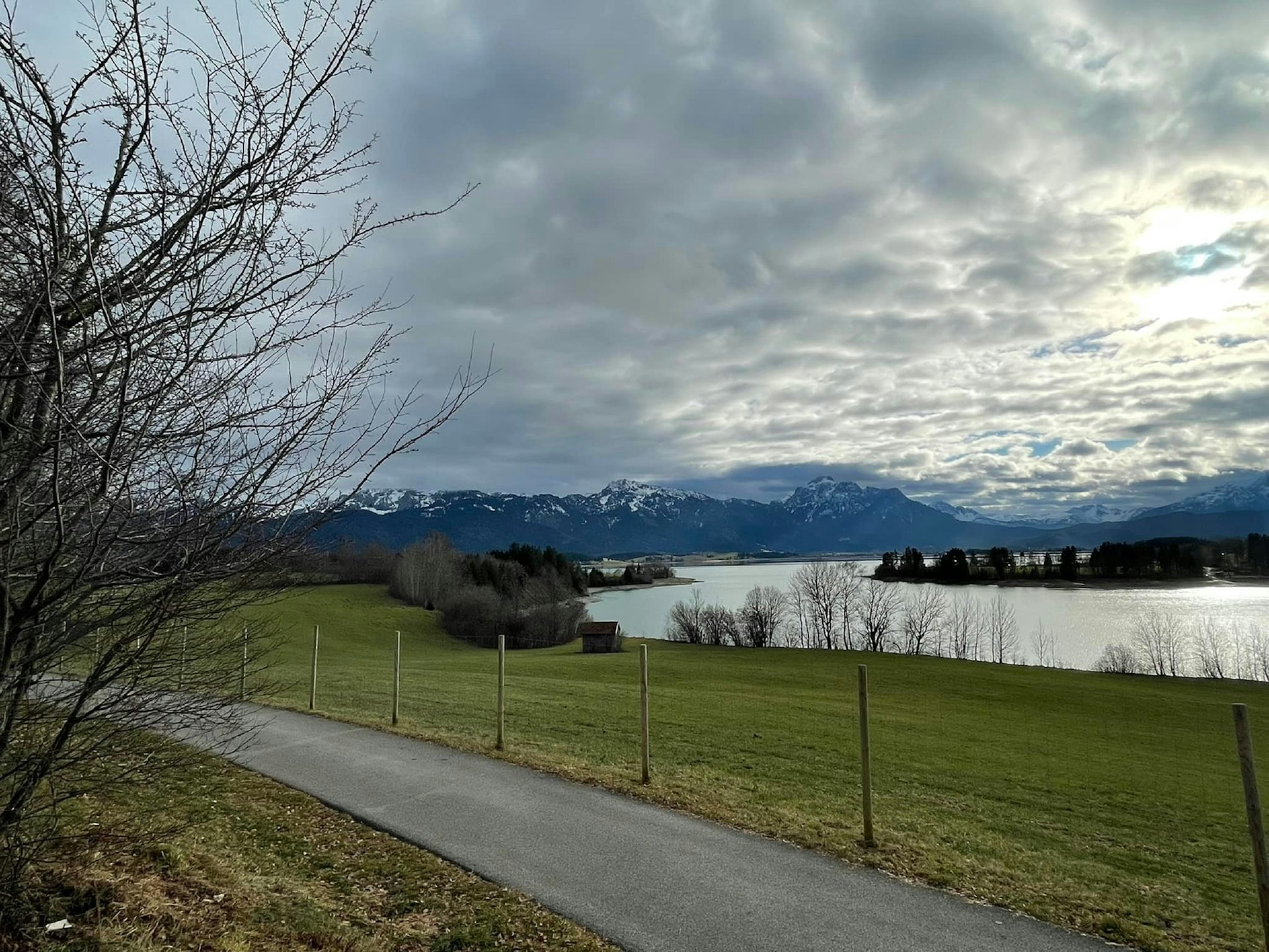 a path leading to a lake with mountains in the background