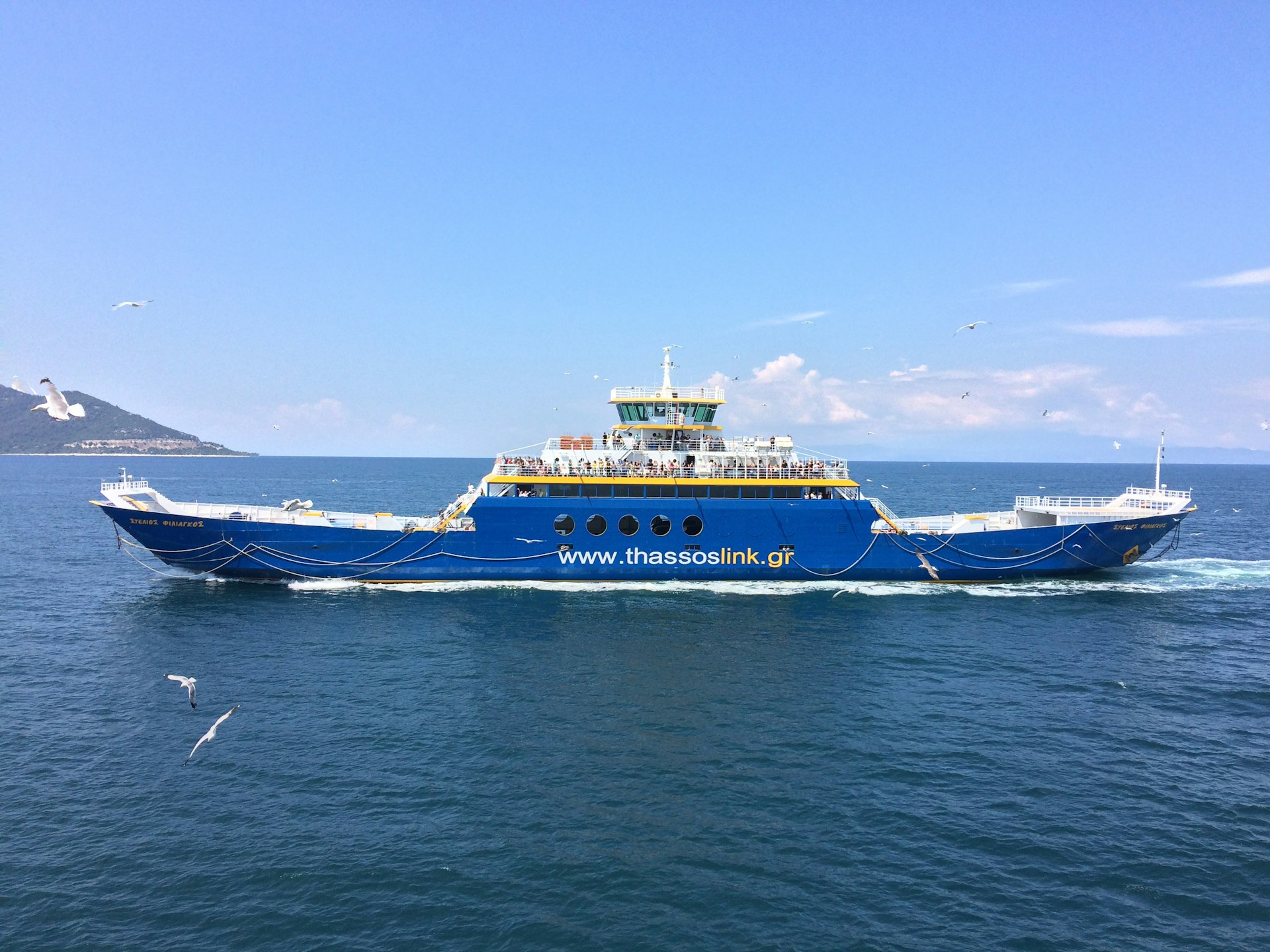 a blue and white boat in the middle of the ocean