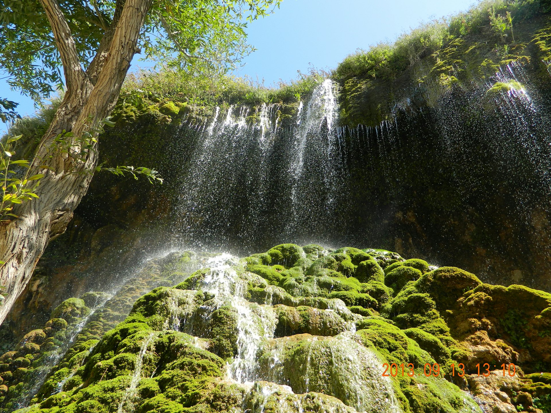 a waterfall with moss growing on the rocks