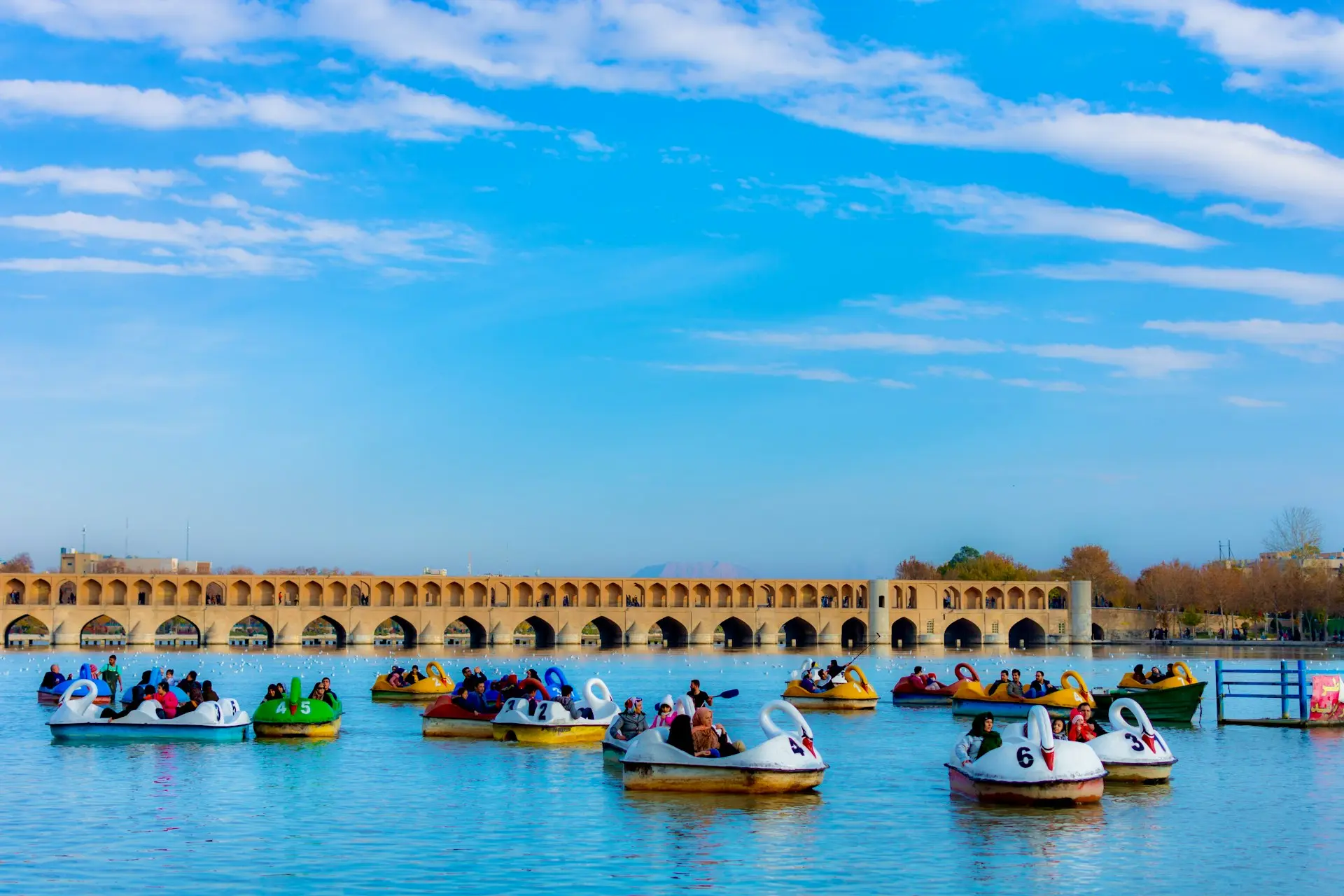 photography of people playing on ride-on boats toy during daytime