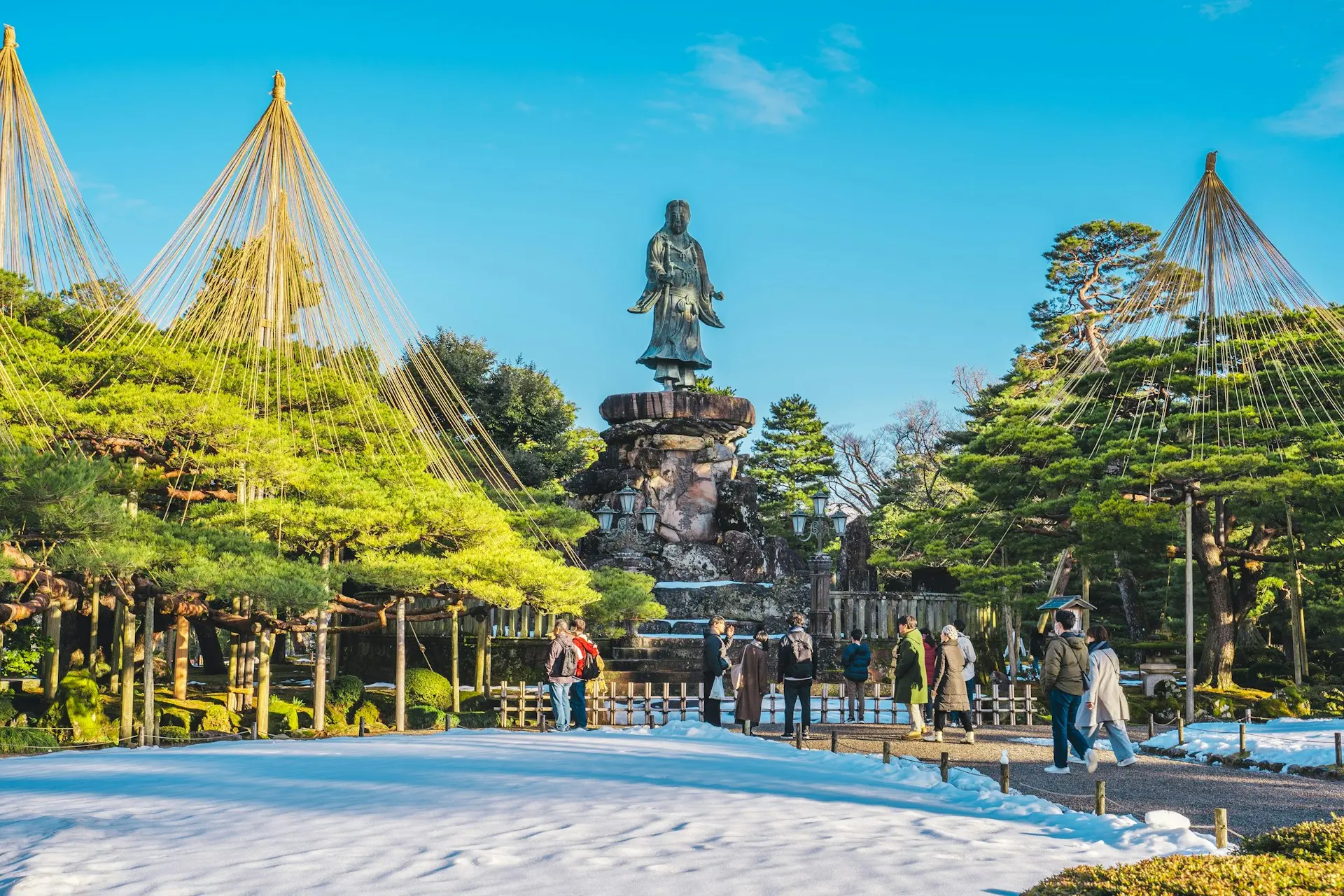 a group of people standing in front of a statue