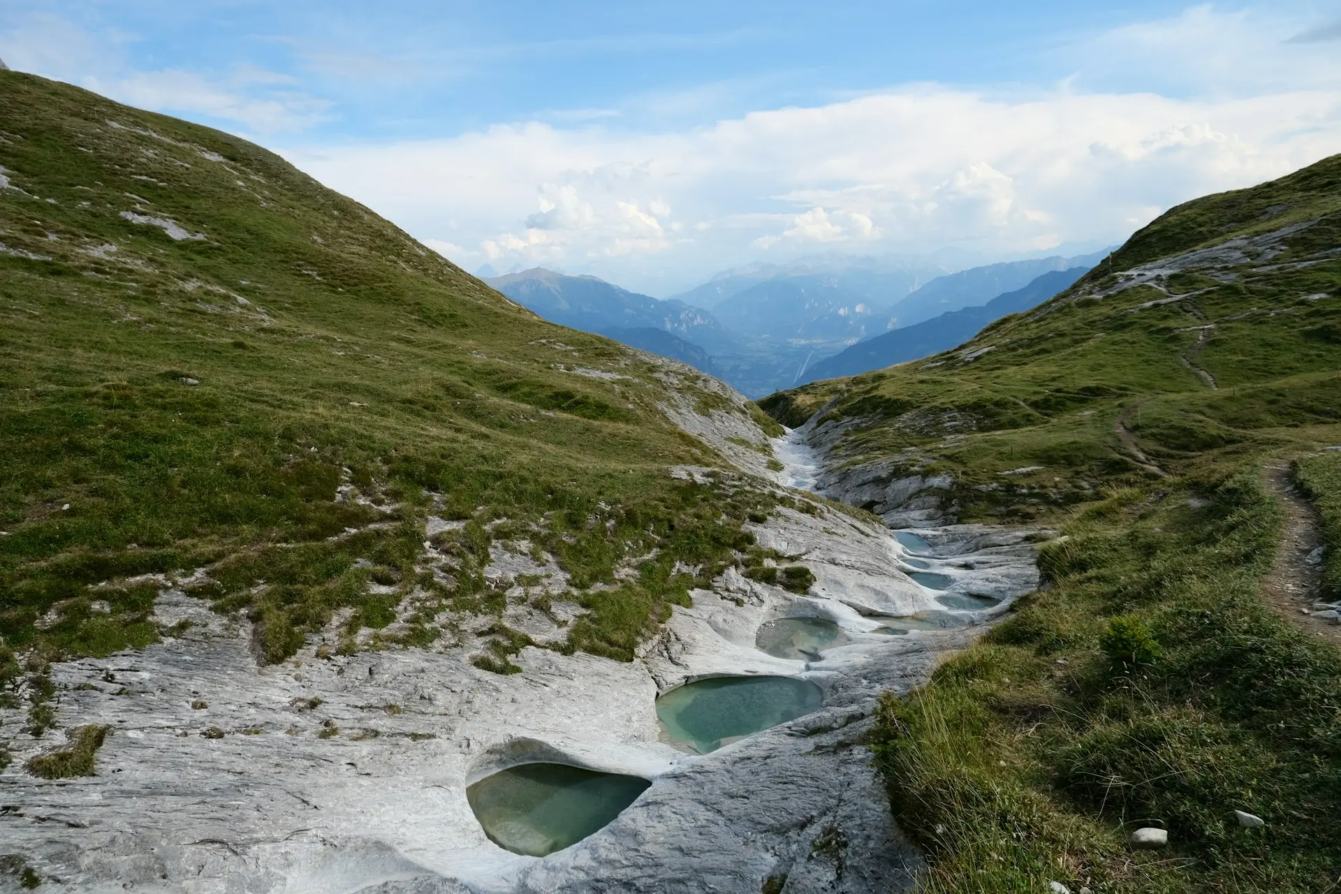 A stream running through a valley surrounded by mountains
