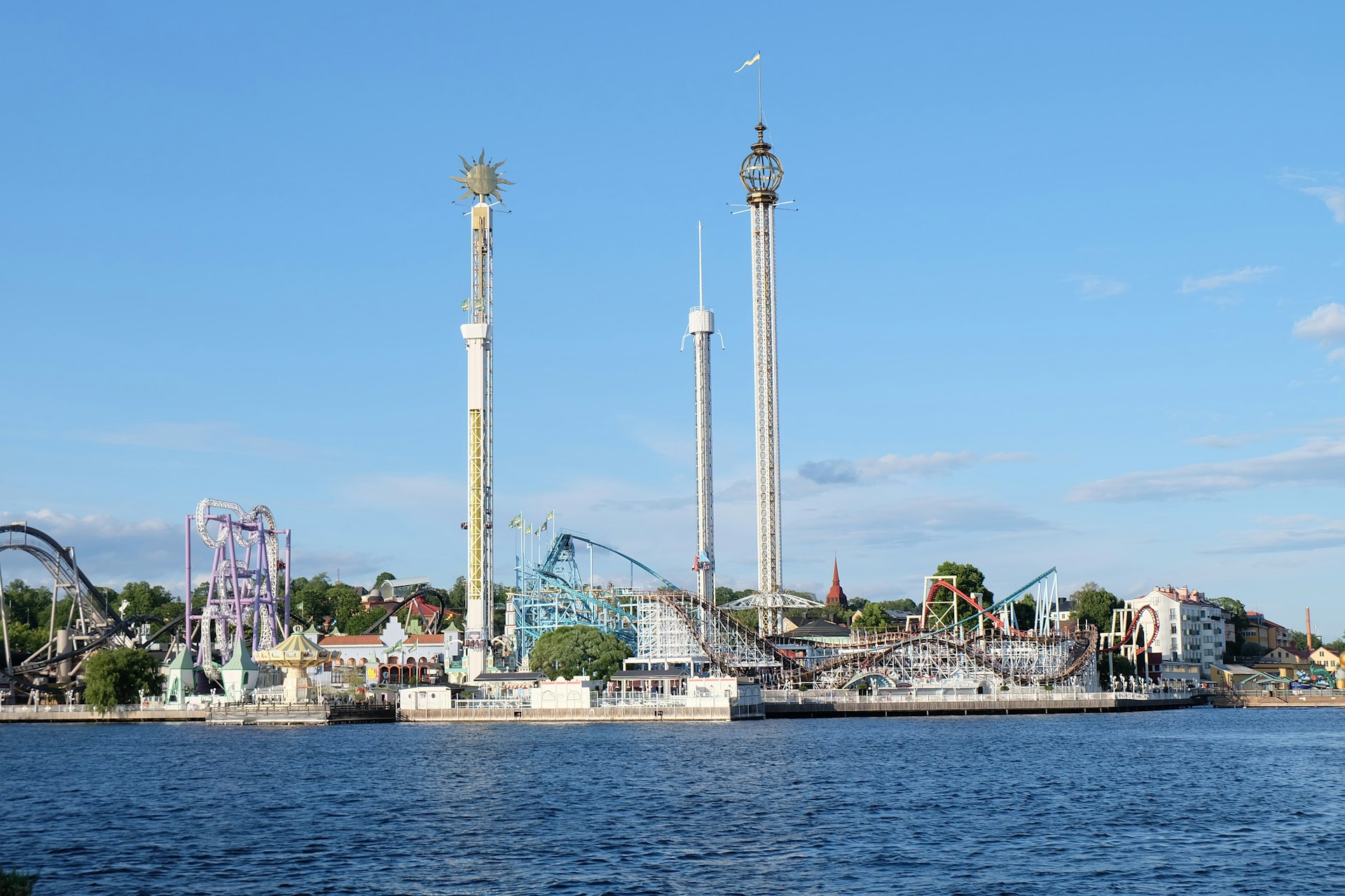 An amusement park sits on the water.