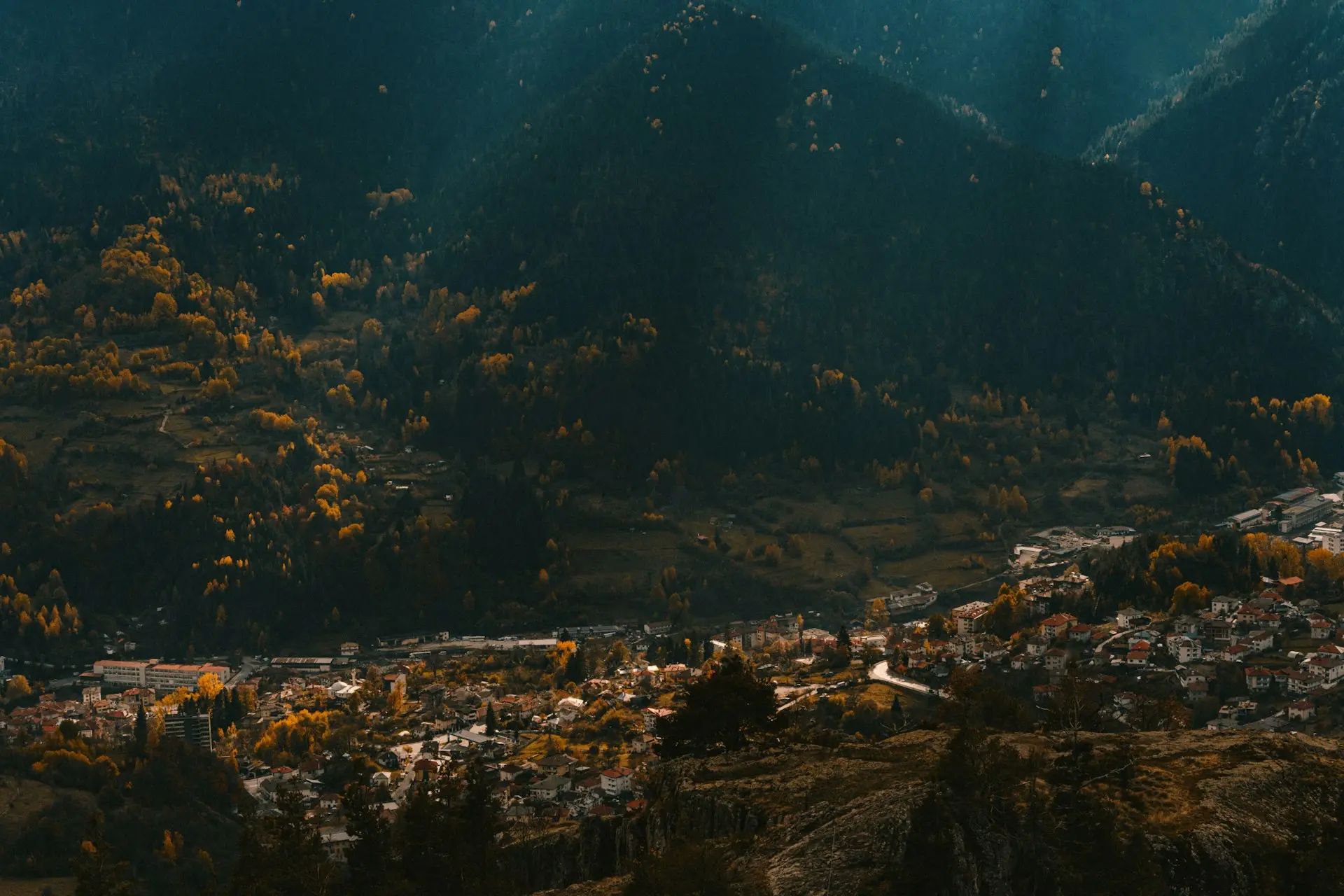 a scenic view of a town surrounded by mountains