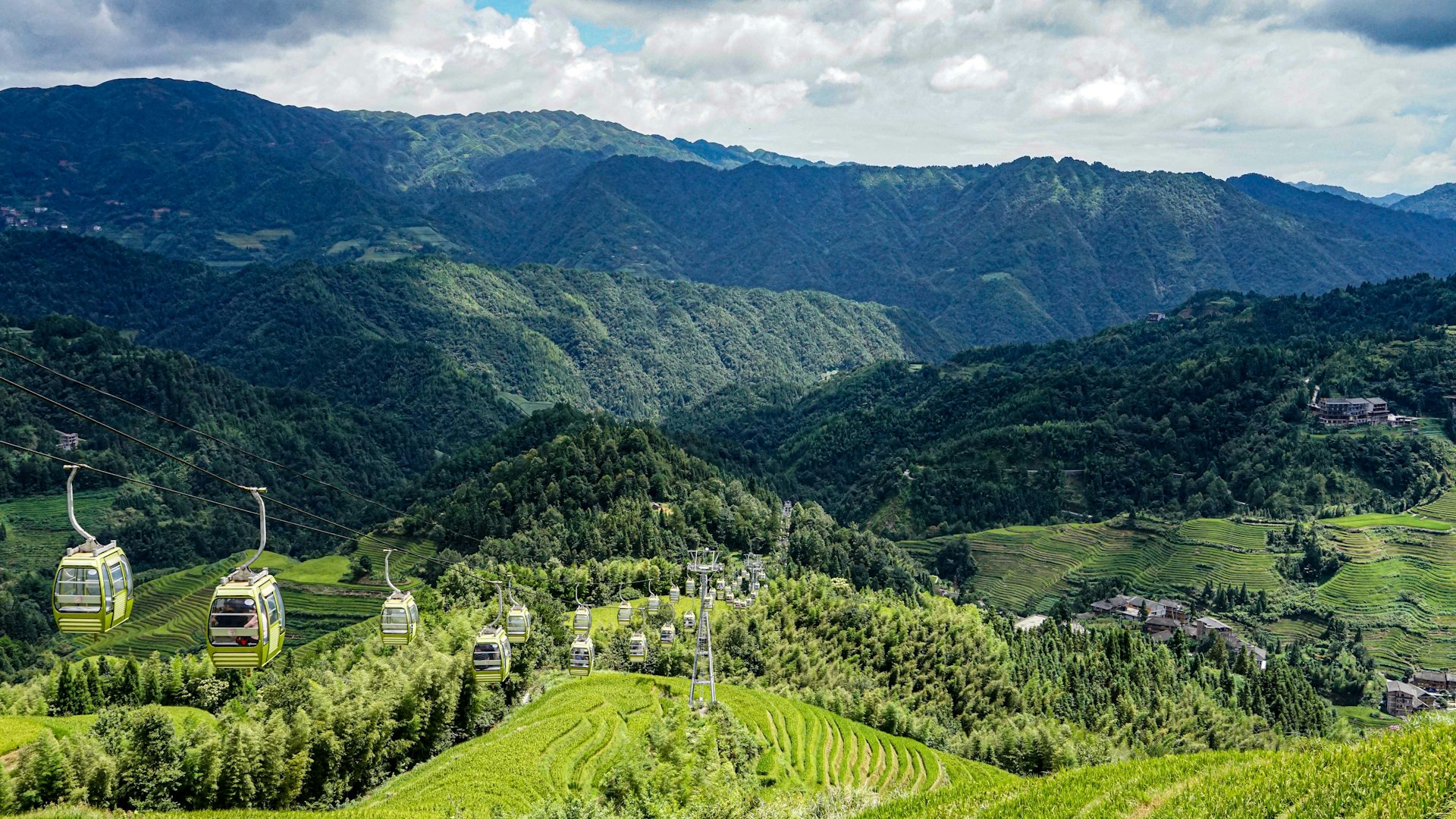 a scenic view of a green valley with mountains in the background