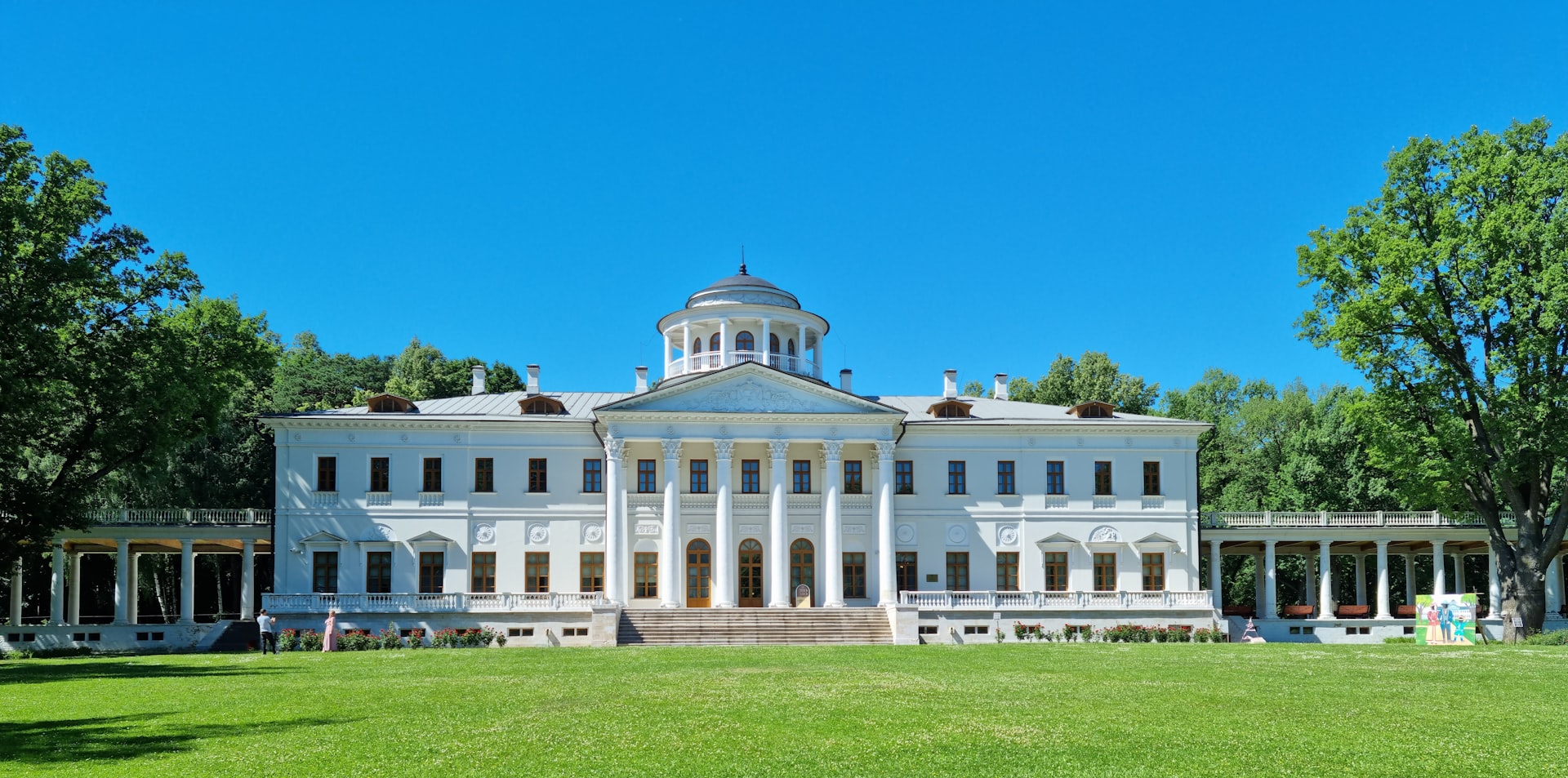 a large white building sitting on top of a lush green field