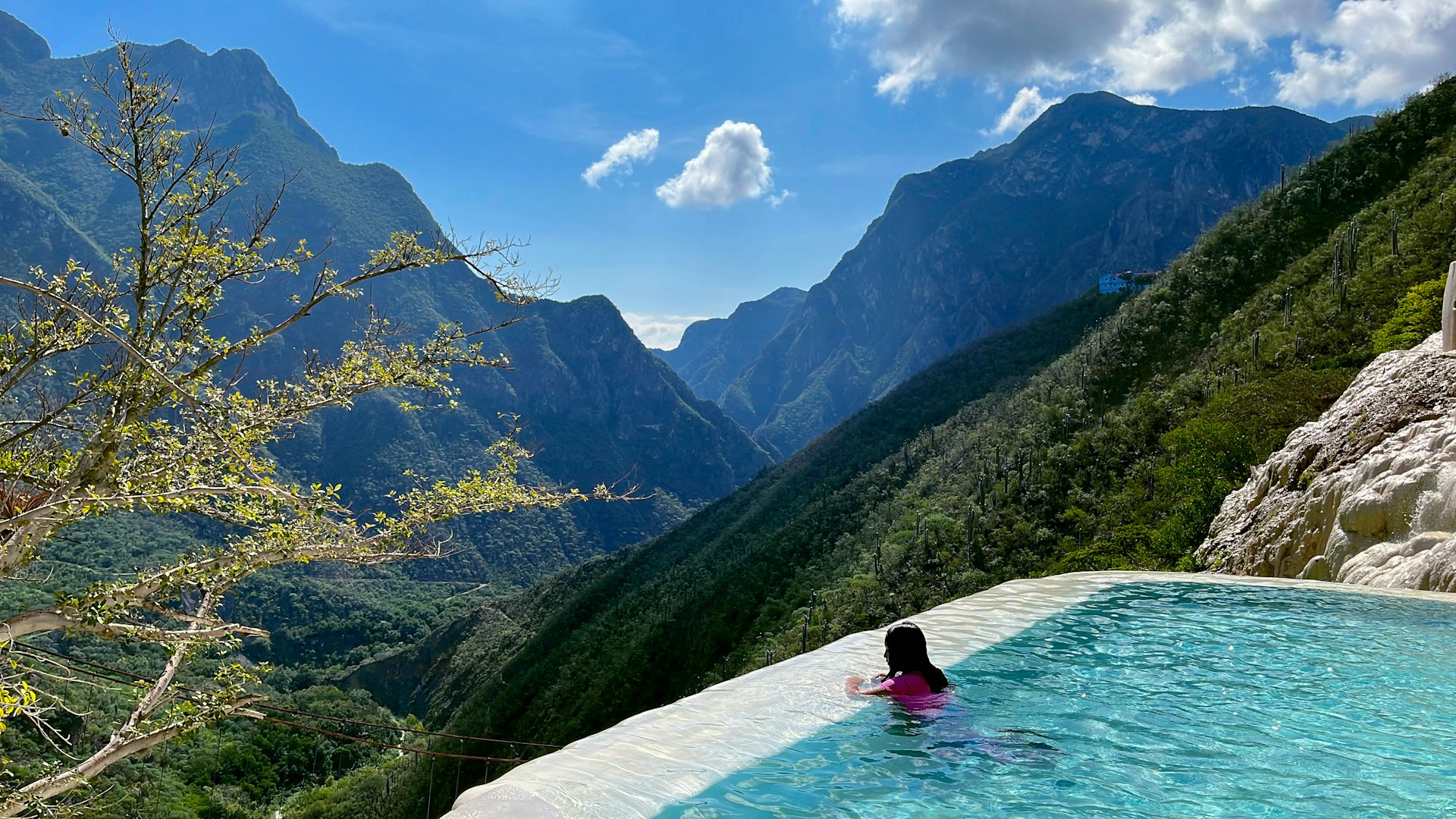a woman in a pink bathing suit sitting in a pool