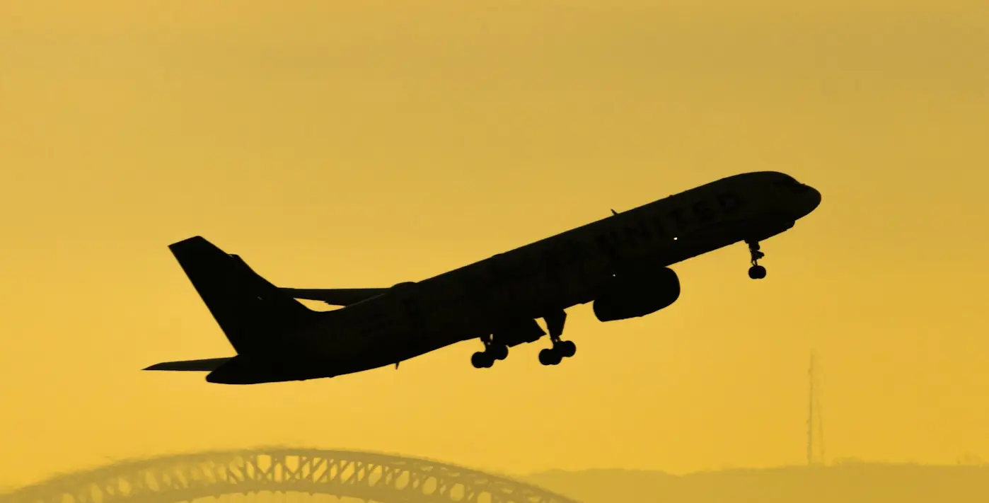 black airplane flying over the city during daytime