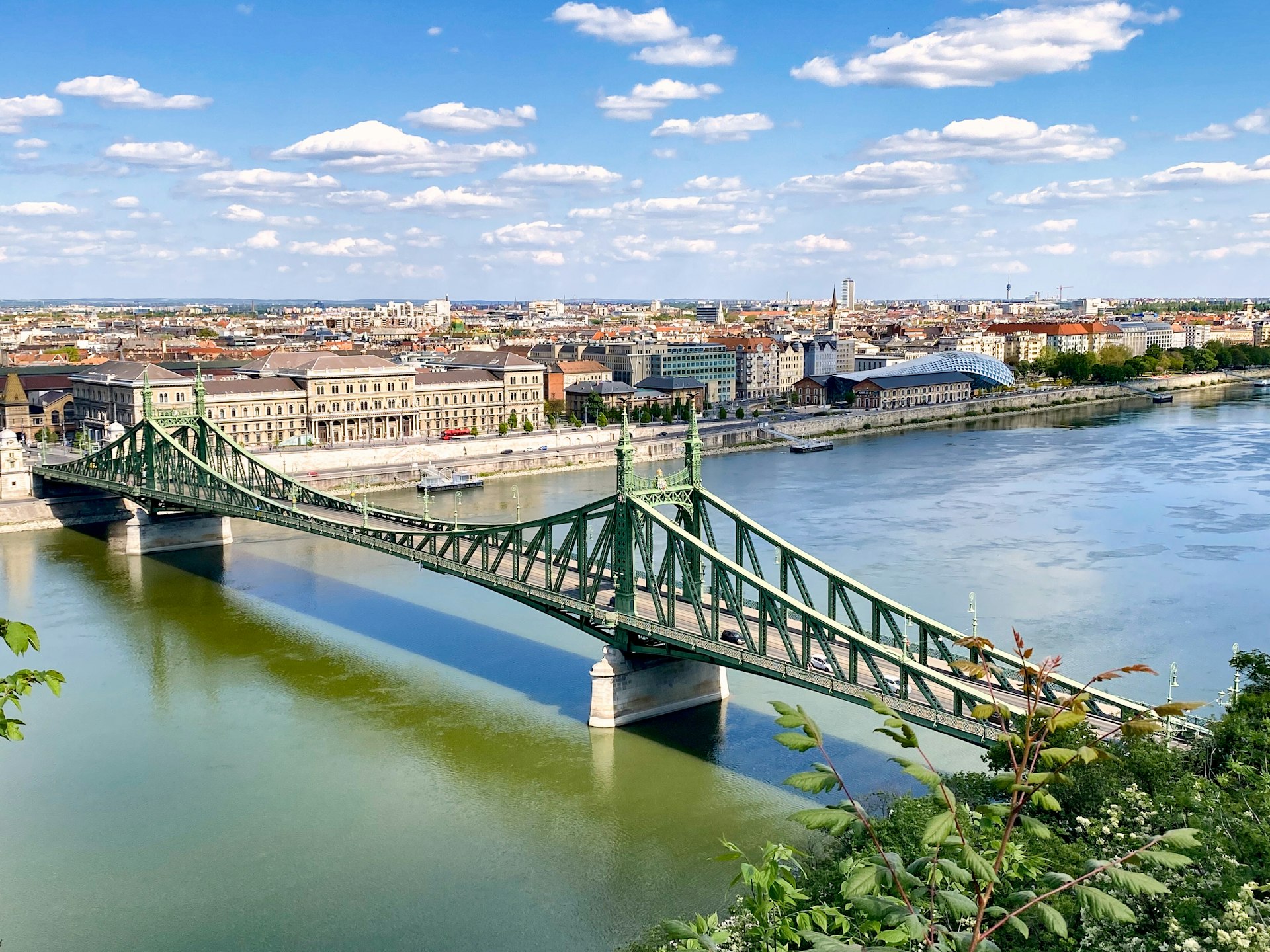 gray concrete bridge over river under blue sky during daytime