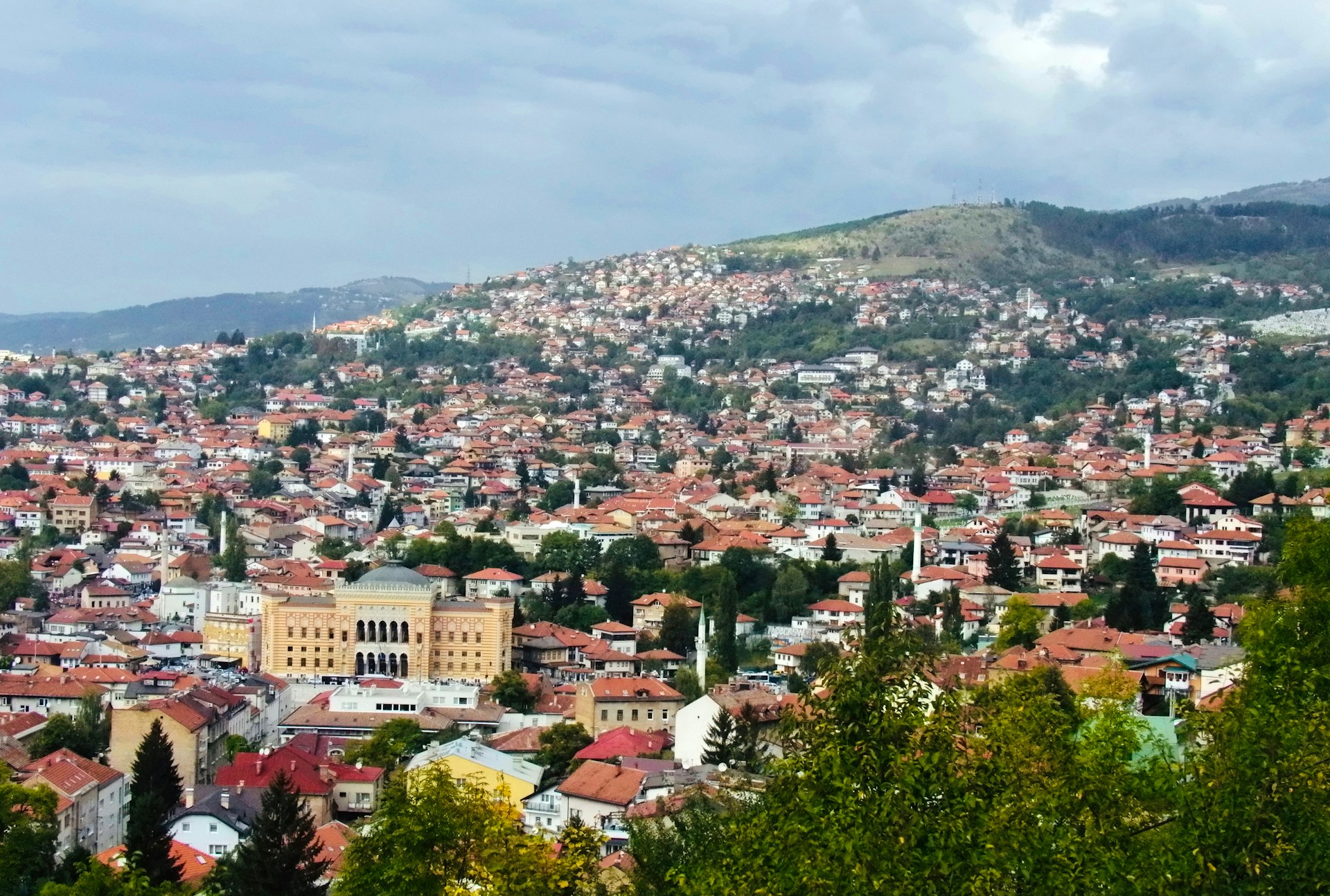 A dense city sprawls across a hilly landscape.