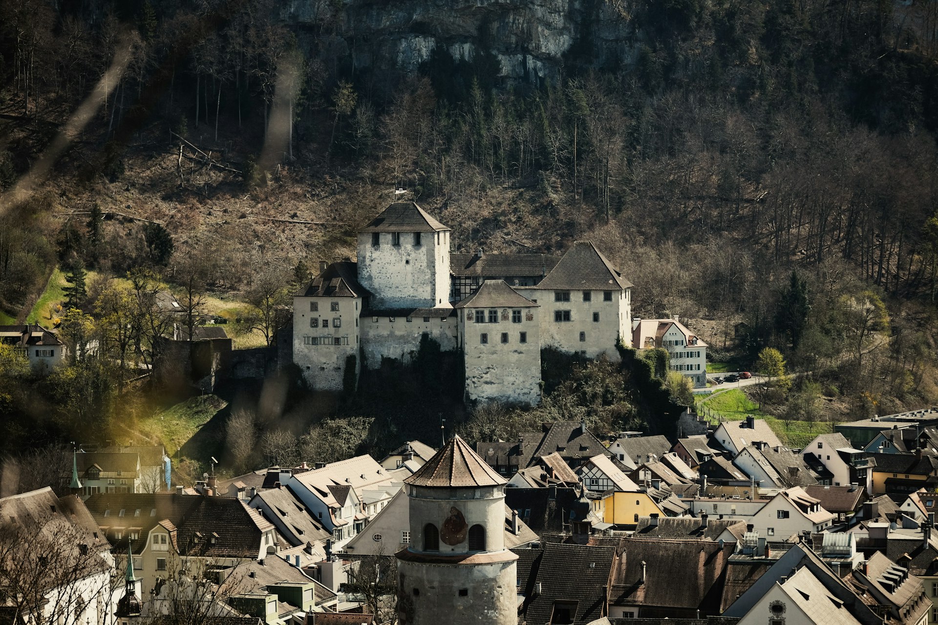 a large white castle sitting on top of a lush green hillside