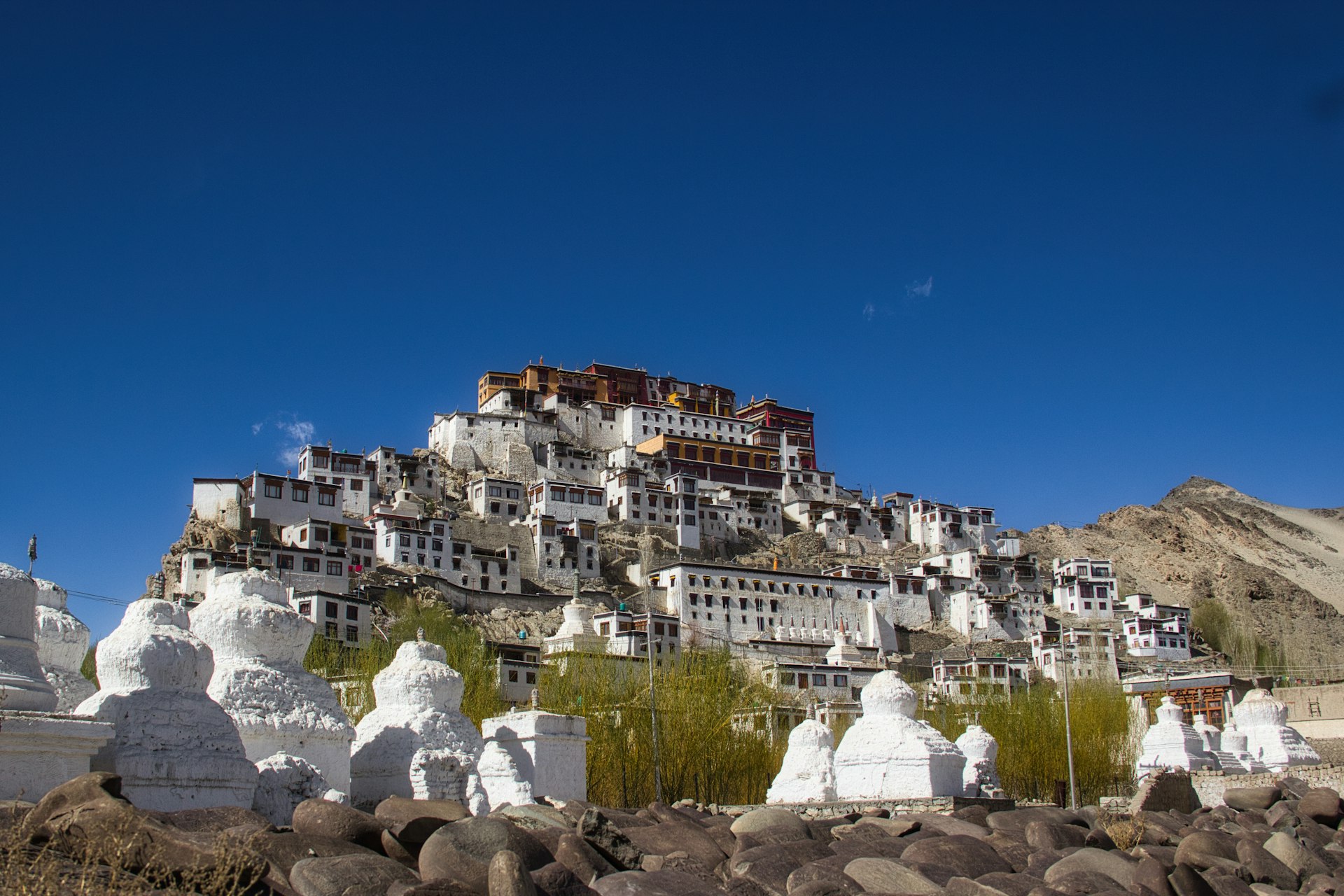 A tibetan monastery sits atop a mountain.