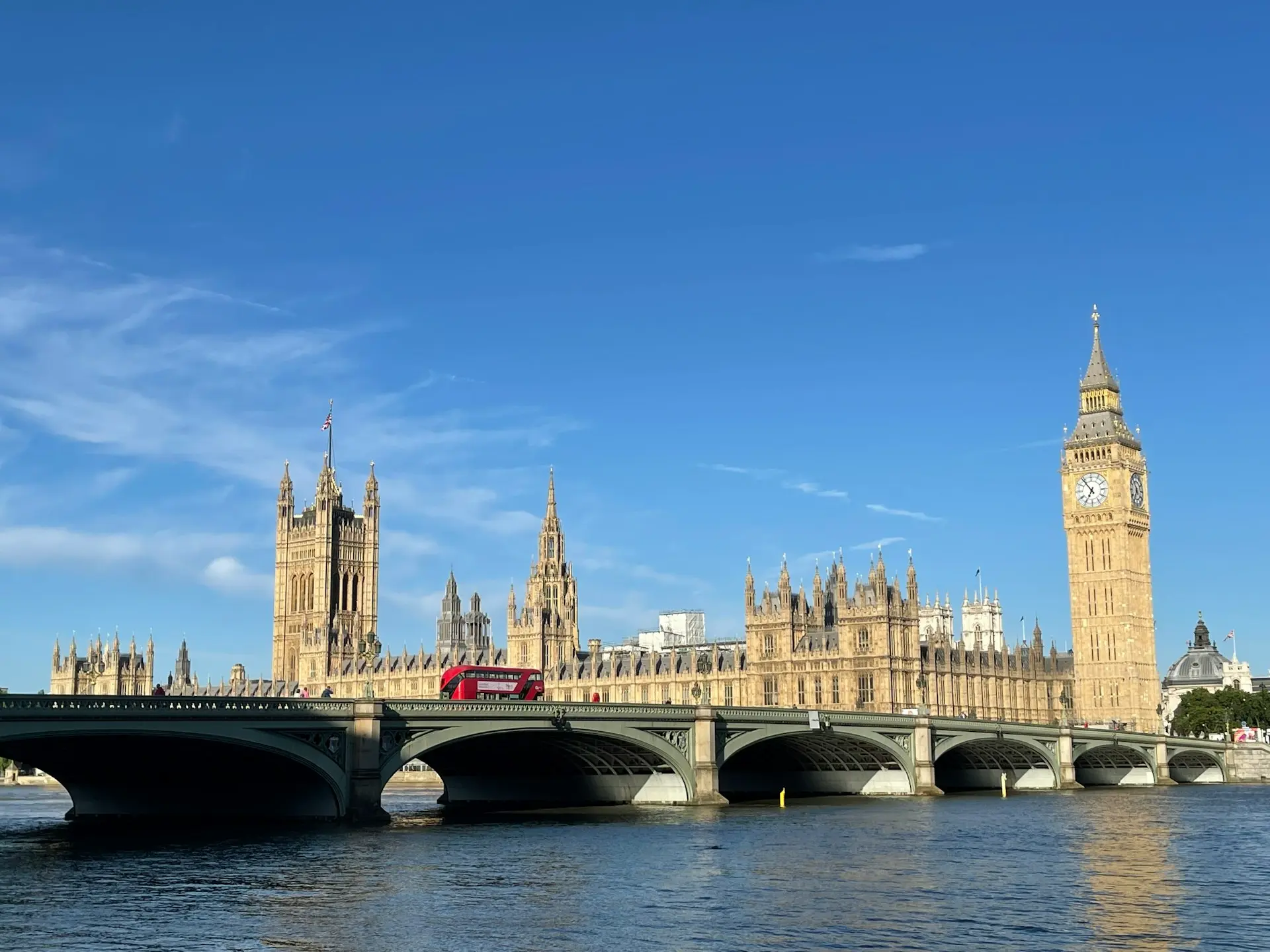 a bridge over a river with a clock tower in the background