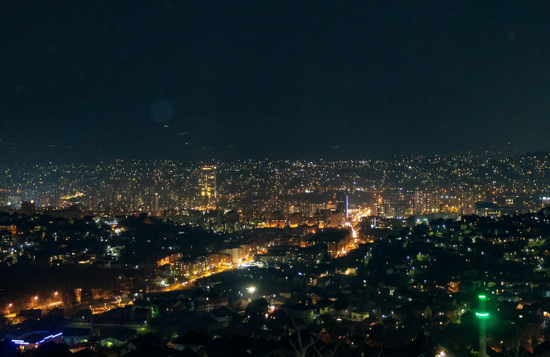 a view of a city at night from the top of a hill