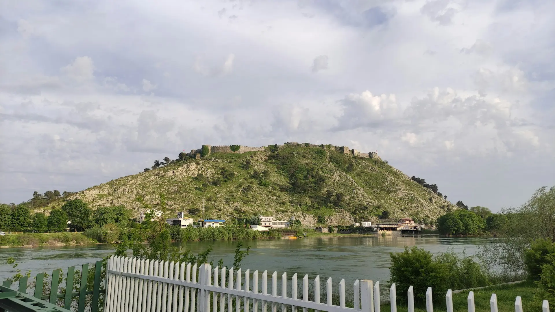a body of water with a hill in the background