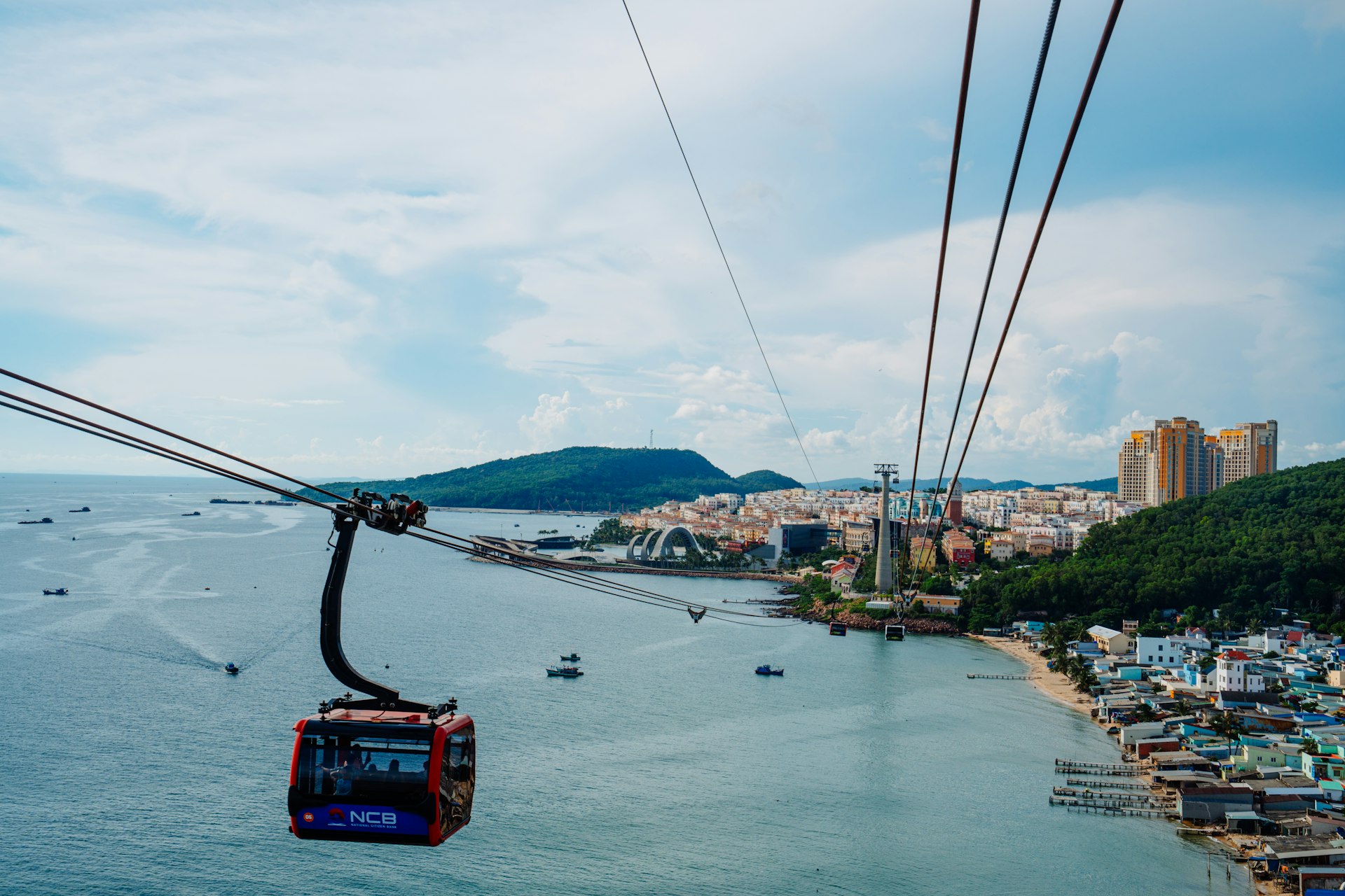 Cable car over the sea with coastal city view