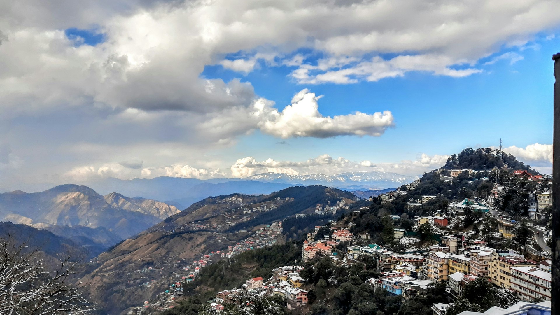 aerial view of city near mountains under cloudy sky during daytime
