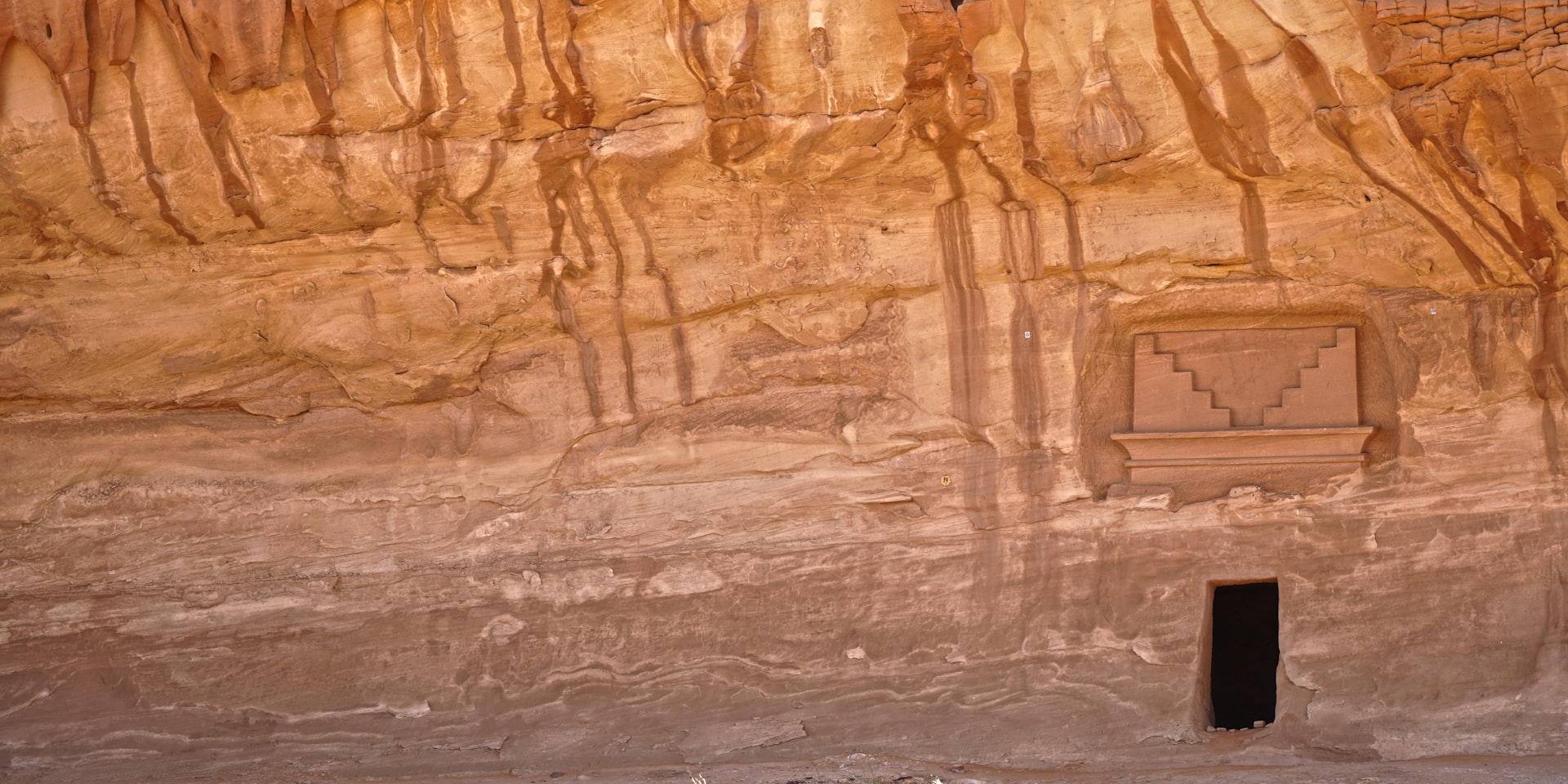 A man standing in front of a carved wall